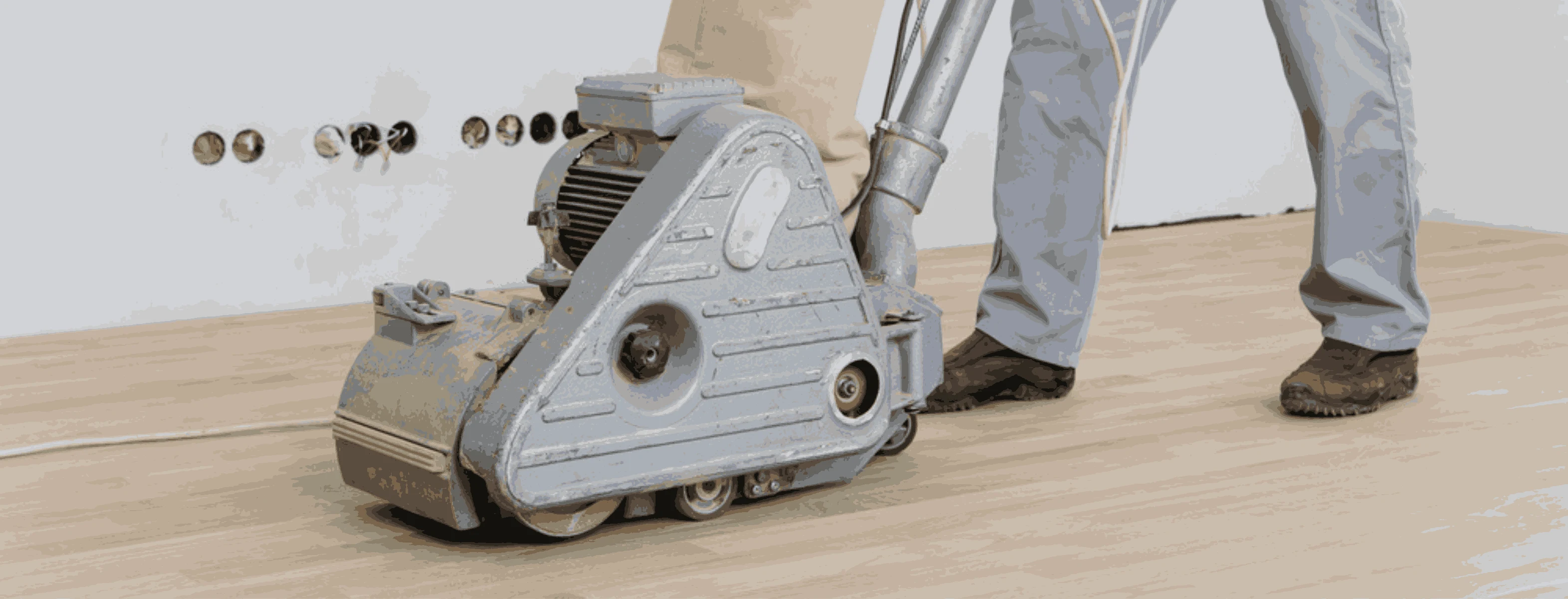 Professional floor sanding in Ladbroke Grove, showcasing meticulous craftsmanship, with machinery and wooden planks in a sunlit room, highlighting restoration process.