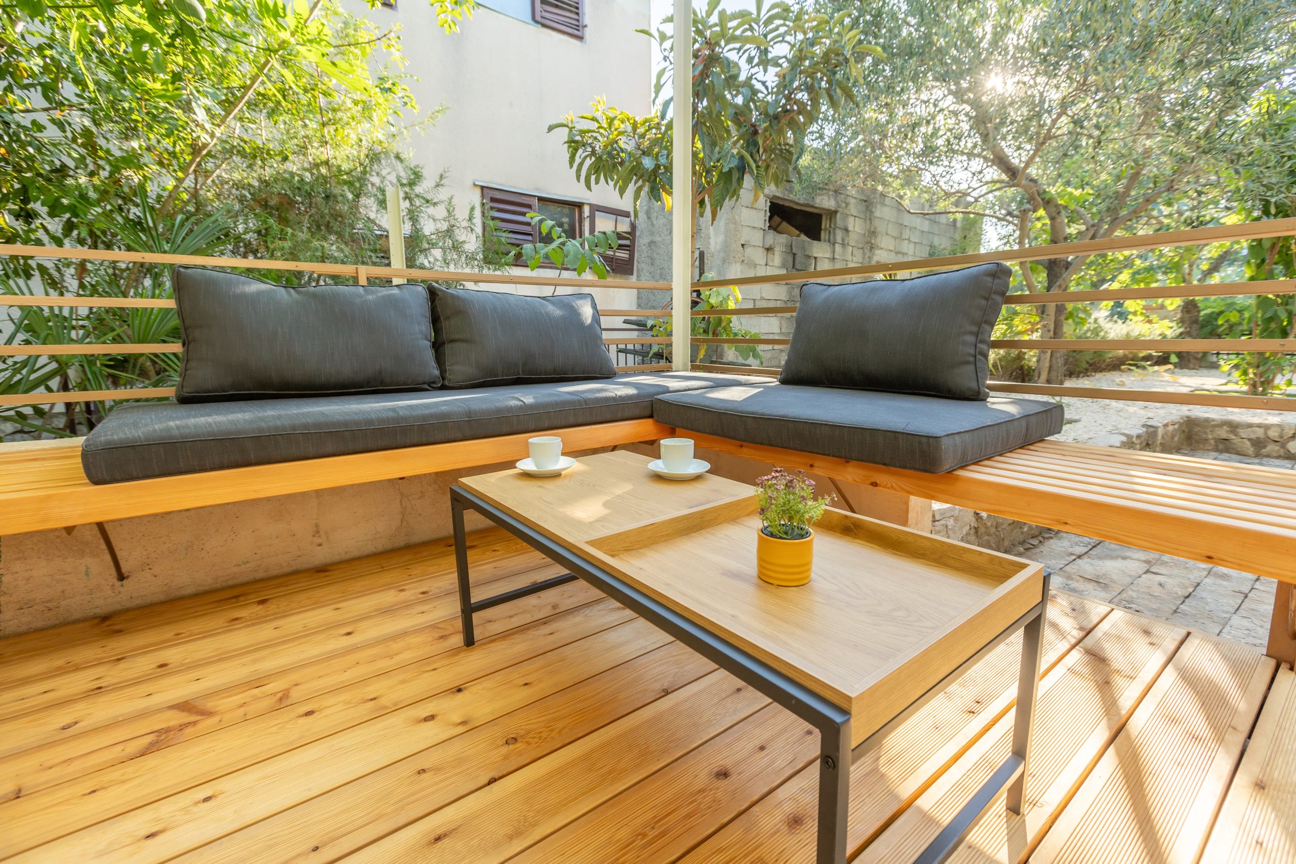 A beautifully restored wooden outdoor patio with a seating area and a small coffee table. The floor appears smooth, even, and free of scratches or imperfections.