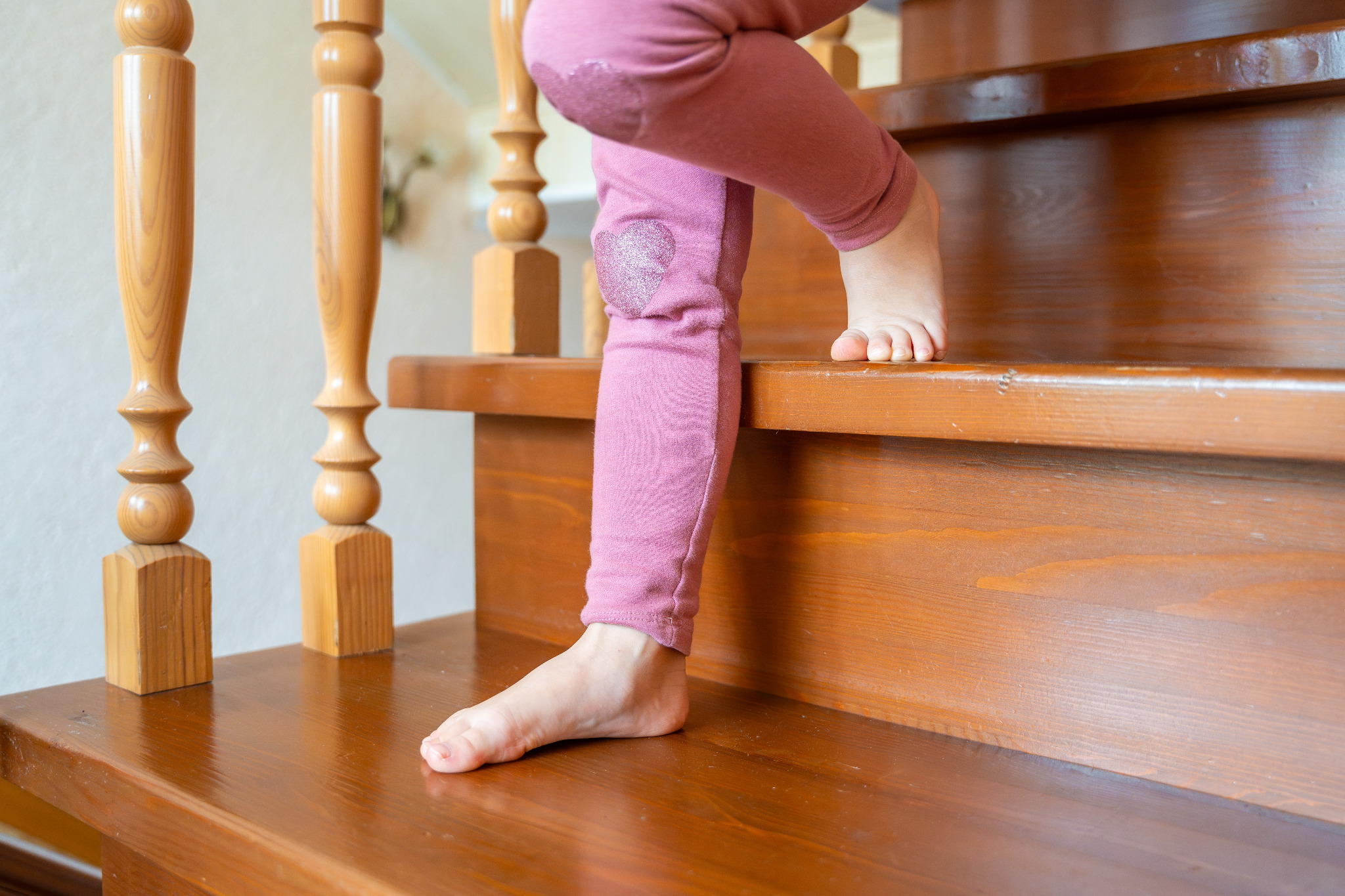 Refinishing Stairs – child’s bare feet on a pine softwood staircase with rounded bullnose nosing, finished in a matt anti-slip coating for safer family use.